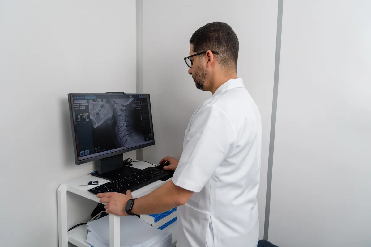 Dr. DOUFAAI analysant un scanner de la colonne vertébrale